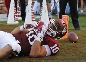 Oklahoma tight end Blake Bell (10) comes up with turf stuck in his helmet during the second quarter of an NCAA college football game against Louisiana Tech in Norman, Okla., Saturday, Aug. 30, 2014. (AP Photo/Sue Ogrocki)